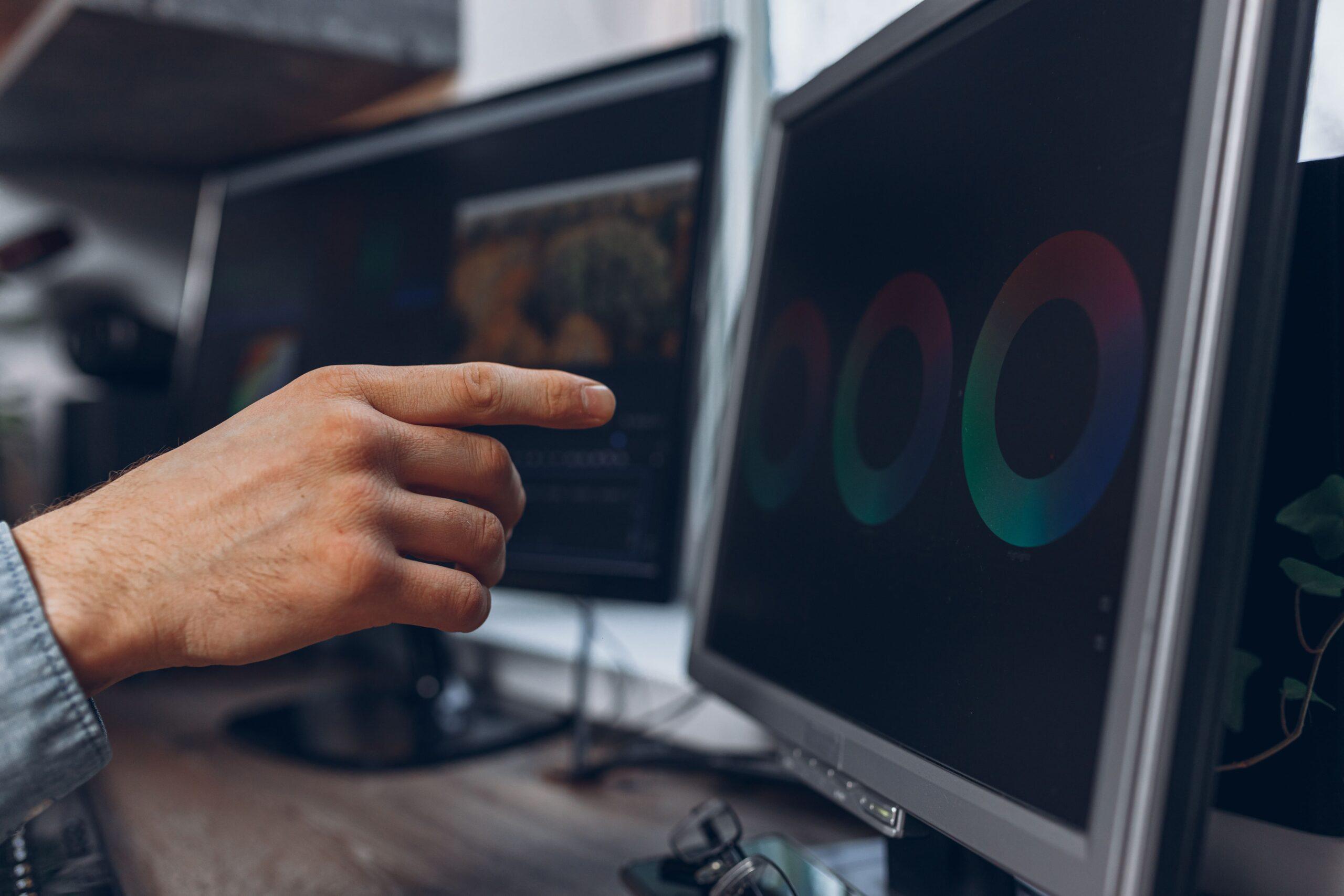 male-video-editor-pointing-desktop-computer-monitor-while-making-montage-post-production